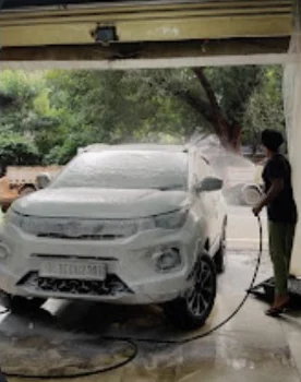 Foam-covered white SUV being washed at Auto Glow, from the supplied business listing
